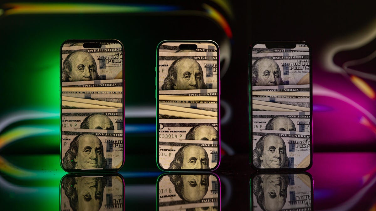 Three iPhones each showing a close up of several $100 bills