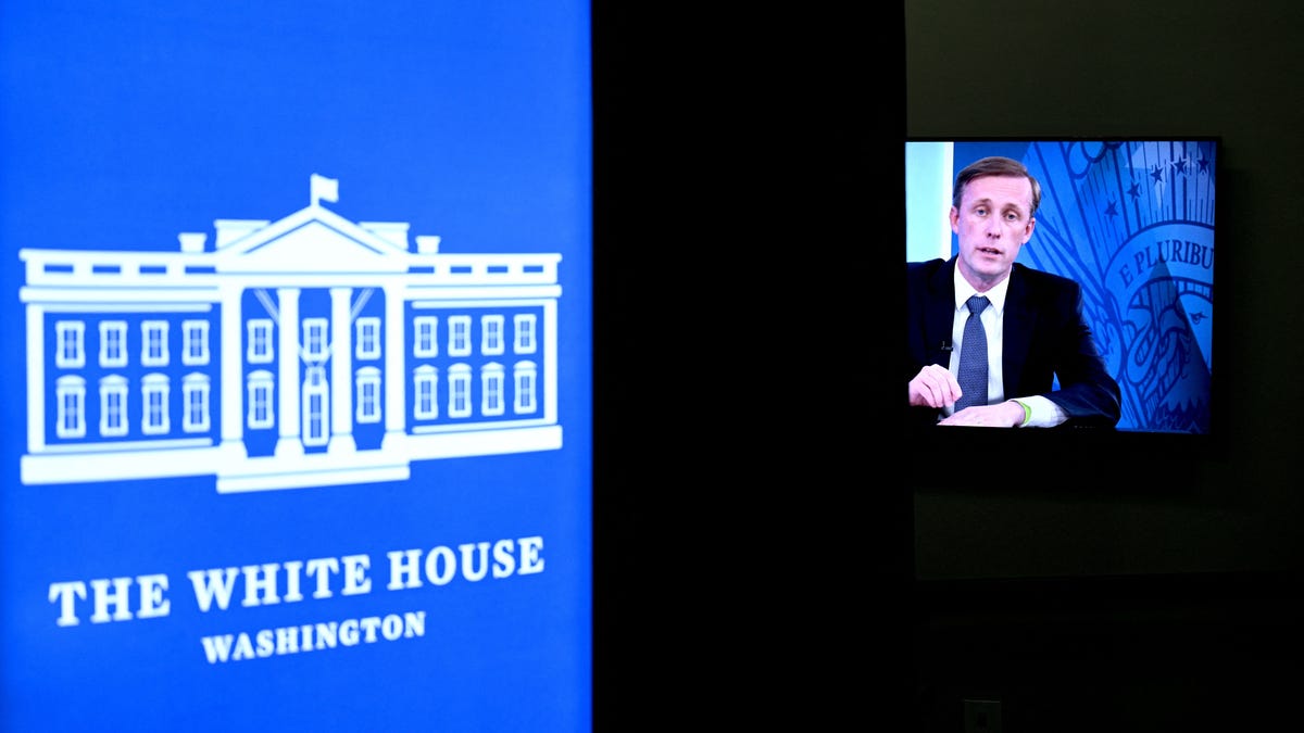 A government official speaking with a computer monitor in the foreground.