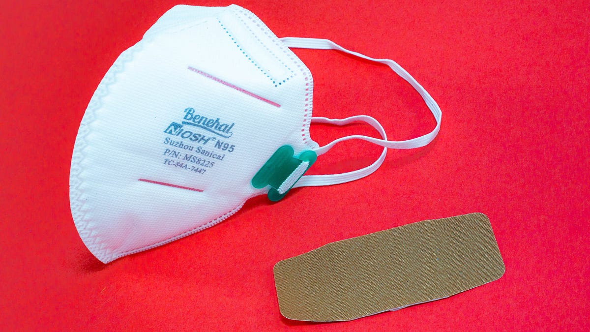 A face mask and bandage on a bright red background