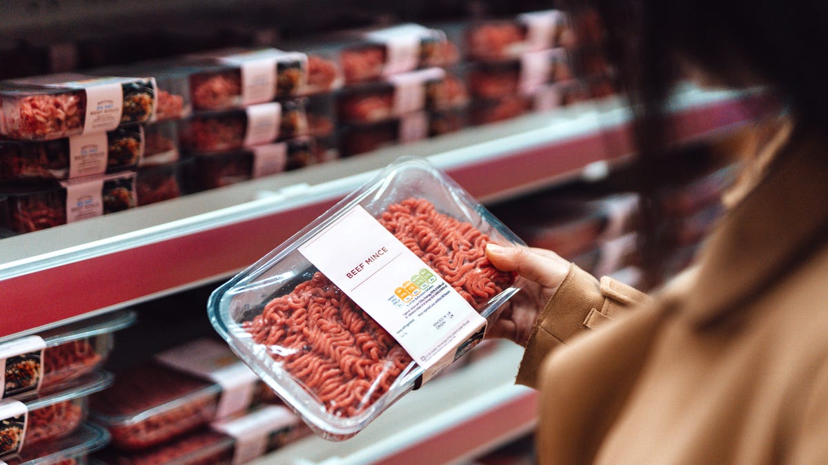 Woman holding ground beef product at the grocery store