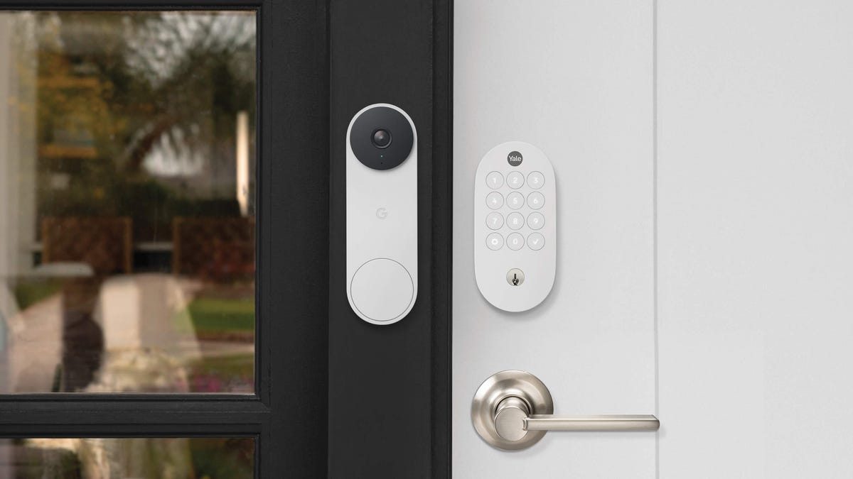 Yale's smart lock on a white door beside a white Nest video doorbell.