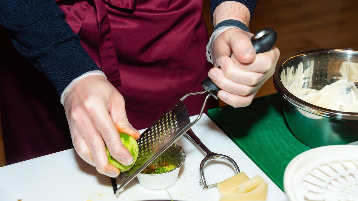 person zesting lime with micrplane