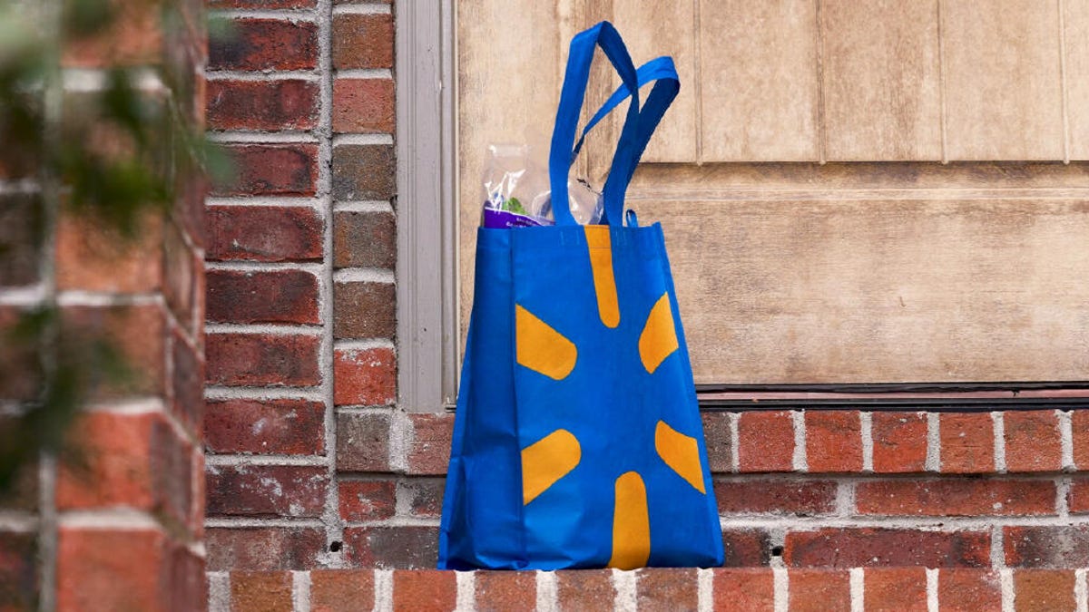 Blue and yellow Walmart bag sits on a brick porch in front of a house.