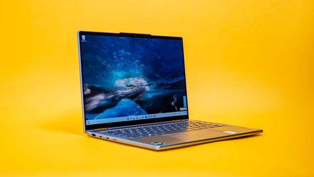 The Lenovo Yoga 7i Gen 7 two-in-one laptop open and facing to the right on a yellow background.