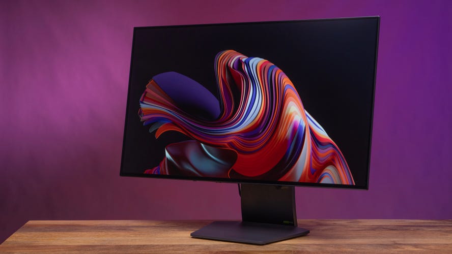 LG Ultragear 32-inch monitor angled left against a purple and magenta background