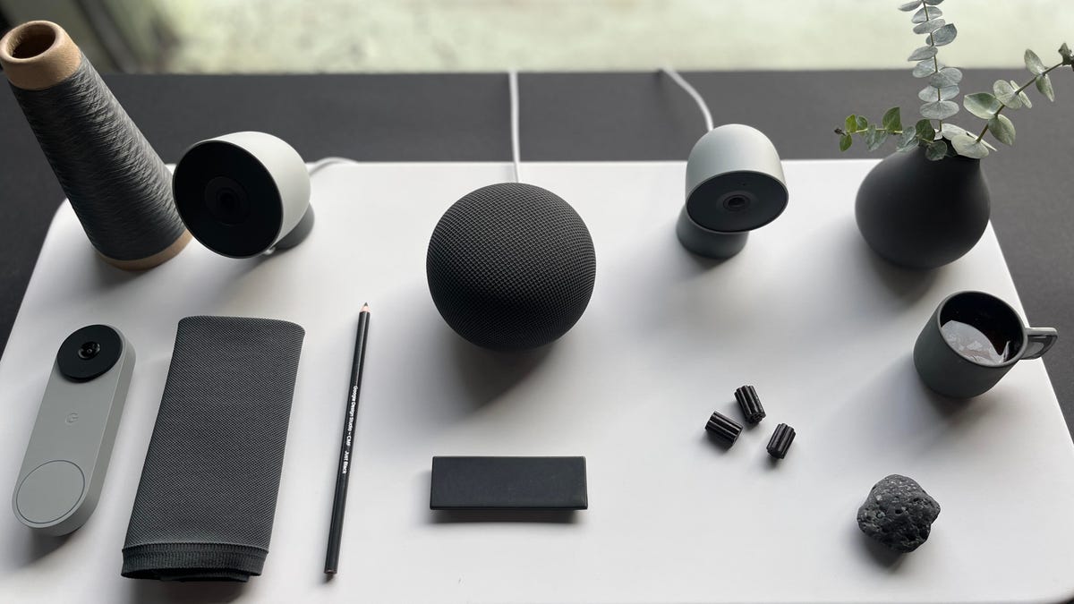 Google Home cameras, doorbell and speaker on a white table.