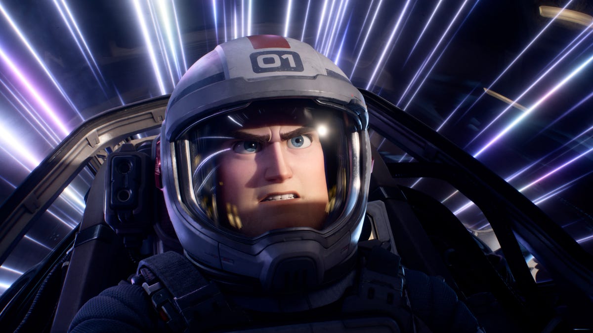 Buzz Lightyear sits in a cockpit, wearing a pilot's helmet, gritting his teeth and knitting his brow as streaks of light flash past..