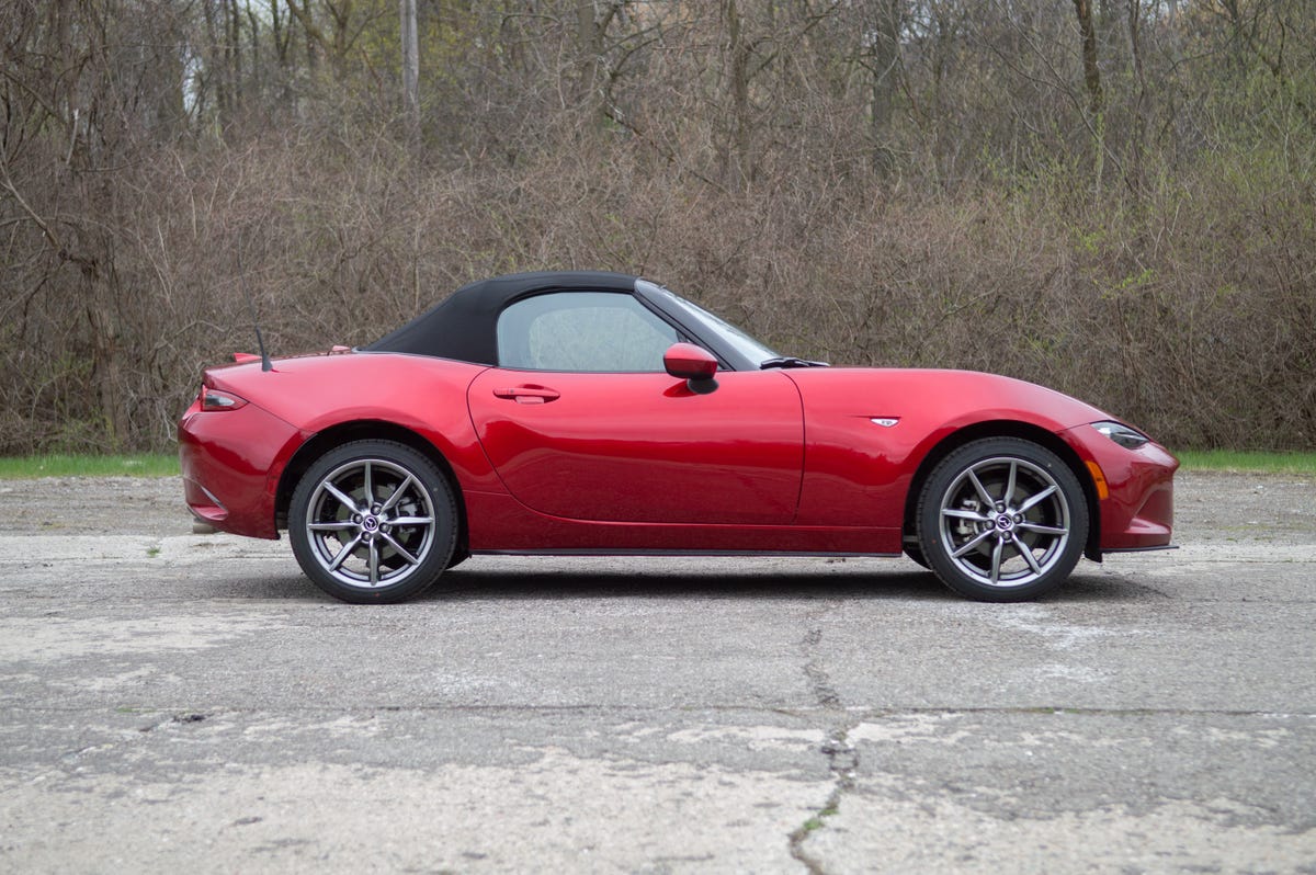 2022 Mazda MX-5 Miata in red, from the passenger side with the roof up