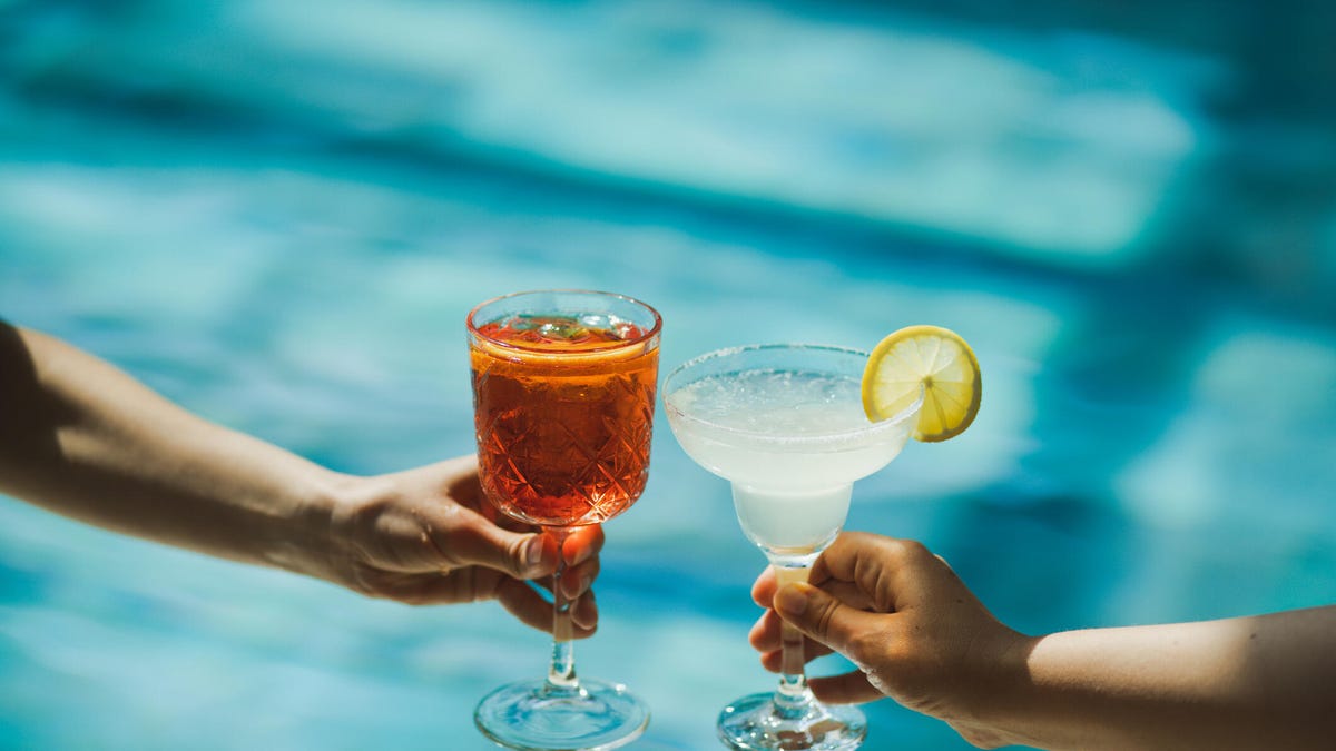 Two people clink drinks