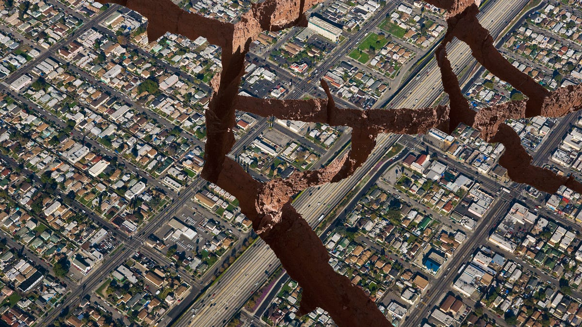 Aerial view of a city with illustrated cracks and crevices from an earthquake.