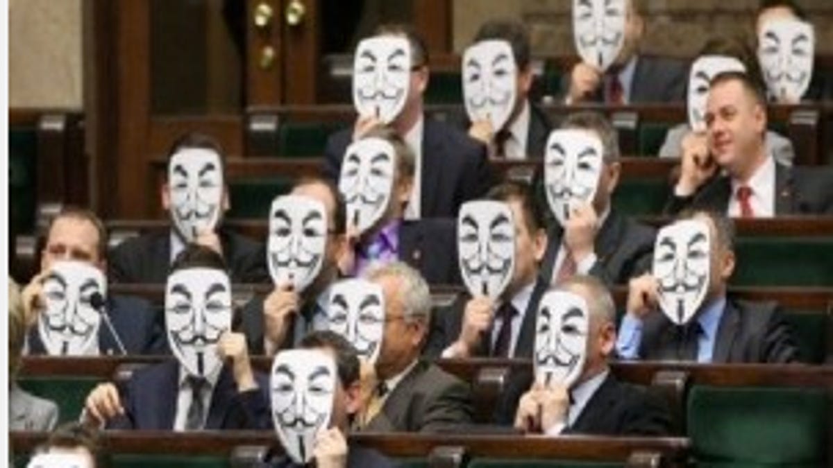 Members of Parliament in Poland express their opposition to ACTA by holding paper Guy Fawkes masks in front of their faces. The masks are used by members of Anonymous.