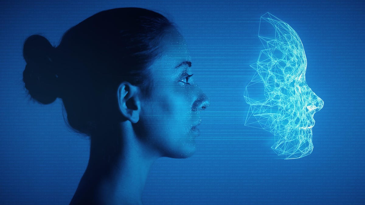 A woman facing sideways against a blue background while a holographic illustration of her face shape hovers in front of her.