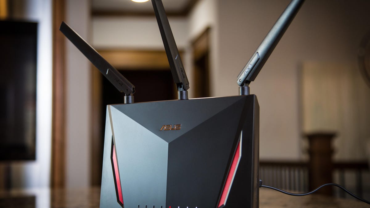 An Asus router on a table with three antennas