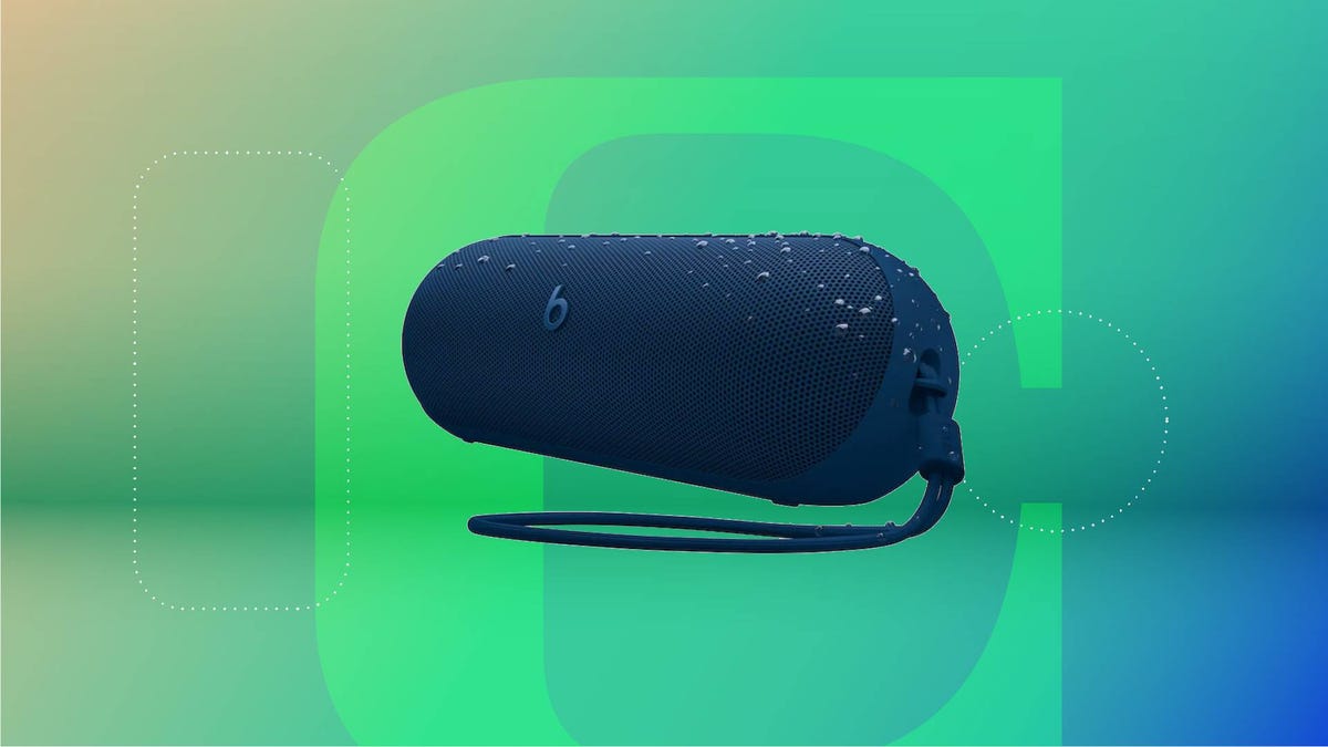 Black Beats pill-shaped Bluetooth speaker with attached black loop. Background: lavender gradient.