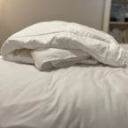 Sijo AiryWeight Comforter on white bed.