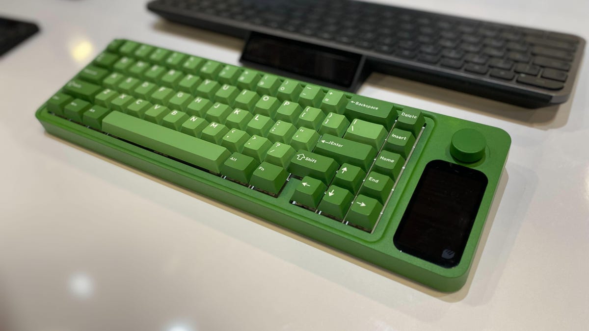A green mechanical keyboard with a black solar cell on the side of it.