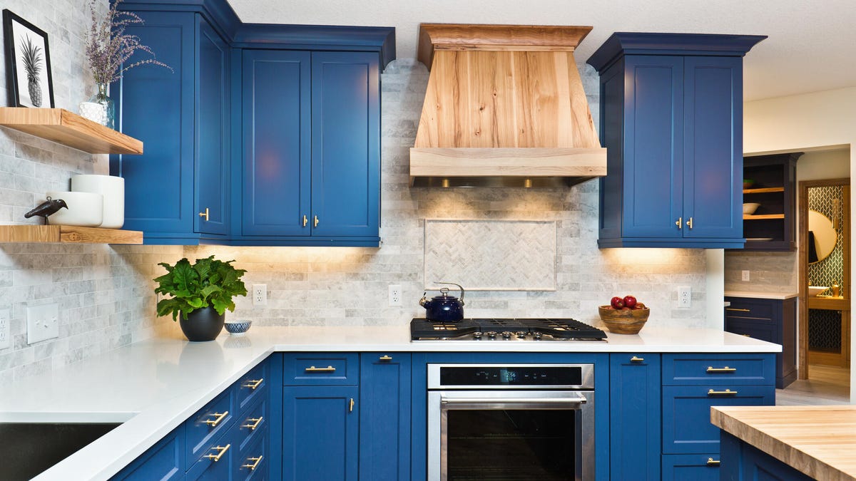 A kitchen with blue cabinets and a white countertop