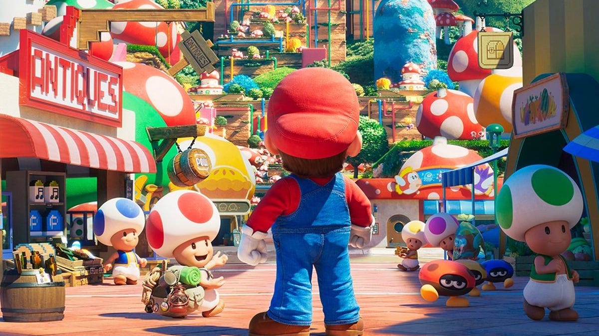 Mario's back is seen as he stares down a colorful Mushroom Kingdom street, with Toads wandering around
