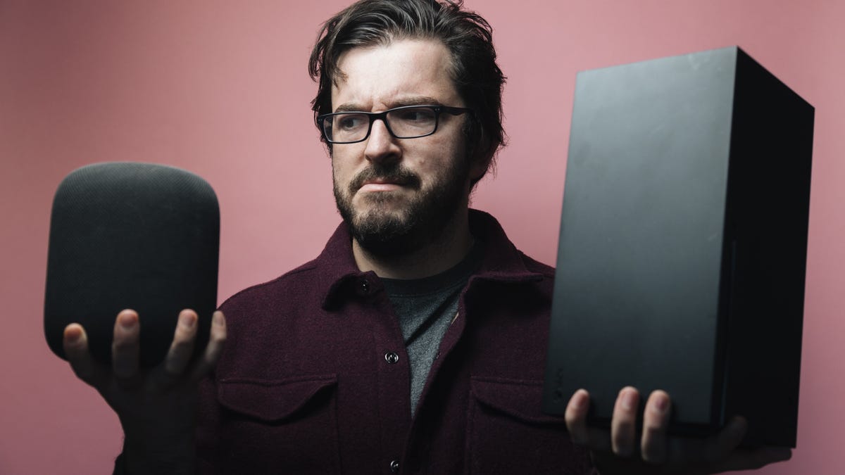 A man holding a speaker and an Xbox games console