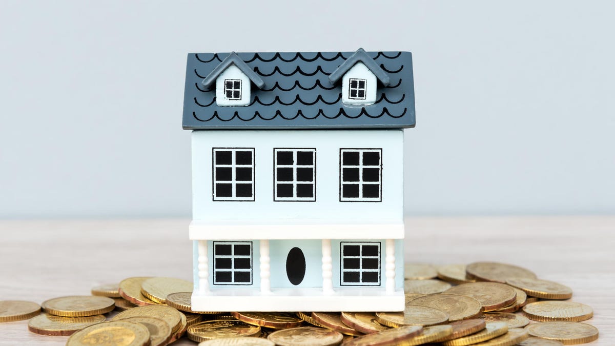A photo illustration of a calculator, mini-house, keys and a spreadsheet for calculating a mortgage