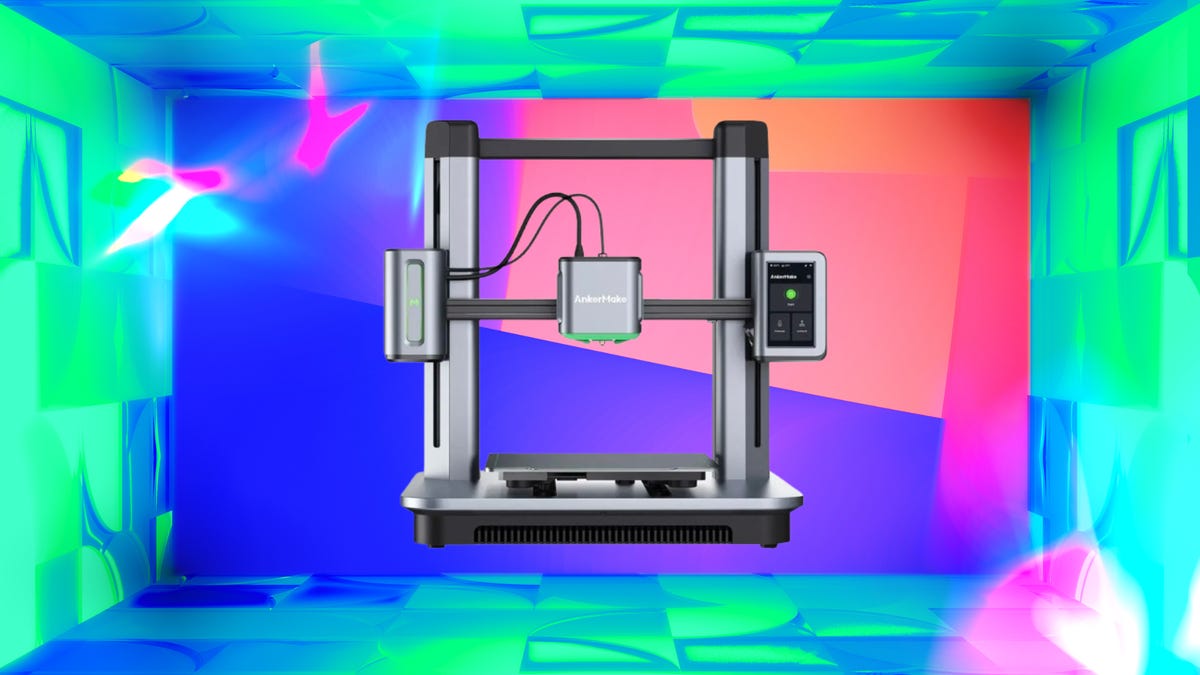 Grey and black 3D printer against purple, blue, cyan pink and green background.