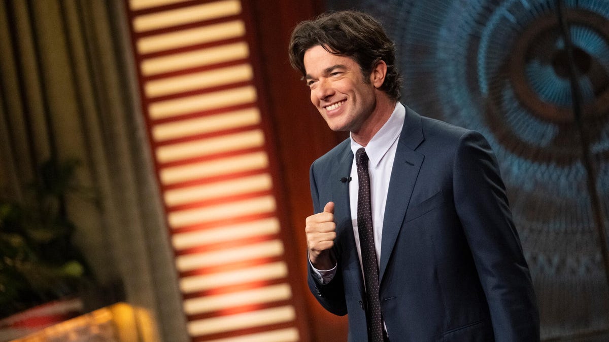 John Mulaney smiling on stage