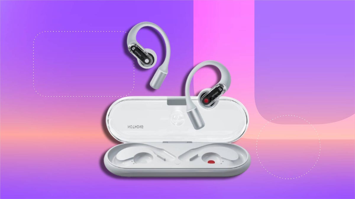 Wireless Nothing earbuds with ear hooks shown inside and outside white charging case, featuring red indicator light. Set against a gradient background in purple, pink and orange with abstract dotted shapes.