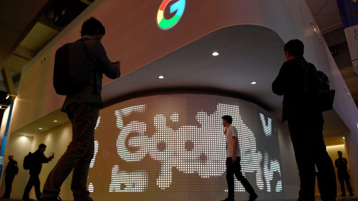 Google logo with people passing by