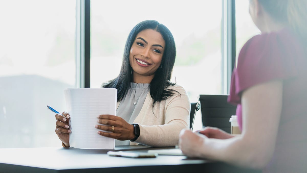 Two business women talking at a desk