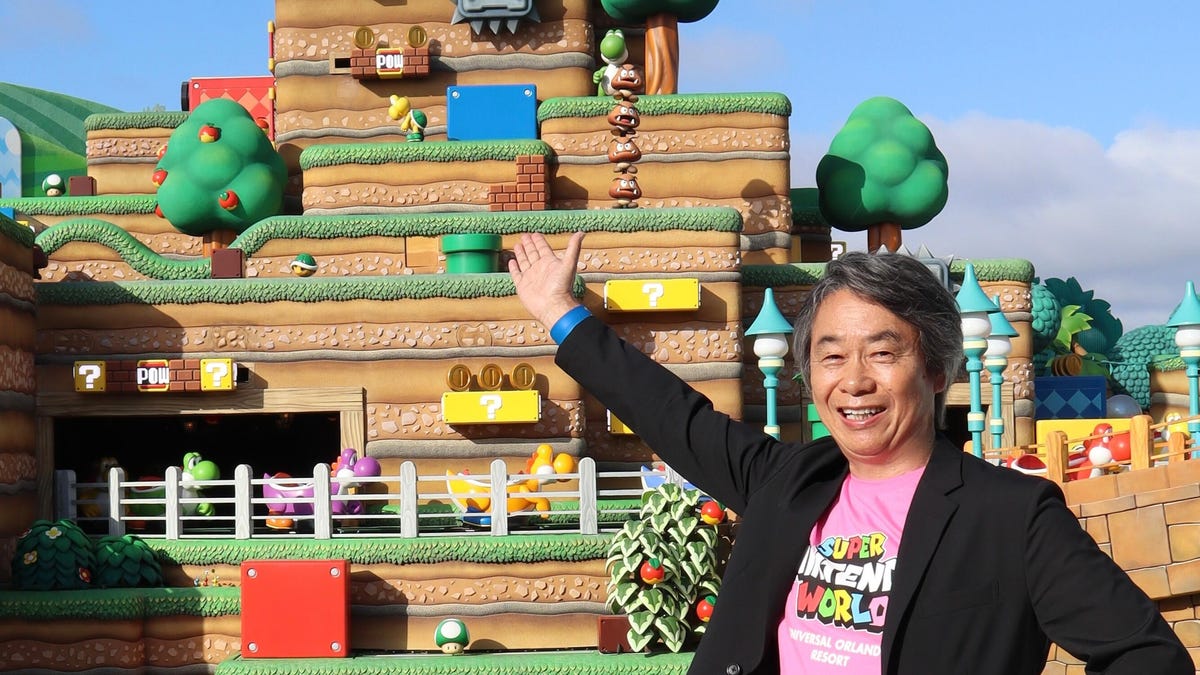 Nintendo's Shigeru Miyamoto standing in front of Epic Universe's Super Nintendo World and its multilevel design.