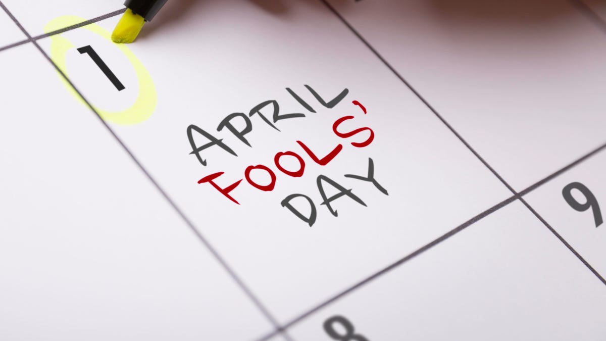 Close-up of a calendar, showing "April Fools' Day" written in the square that denotes April first. Someone is circling the date using a neon yellow highlighter pen.
