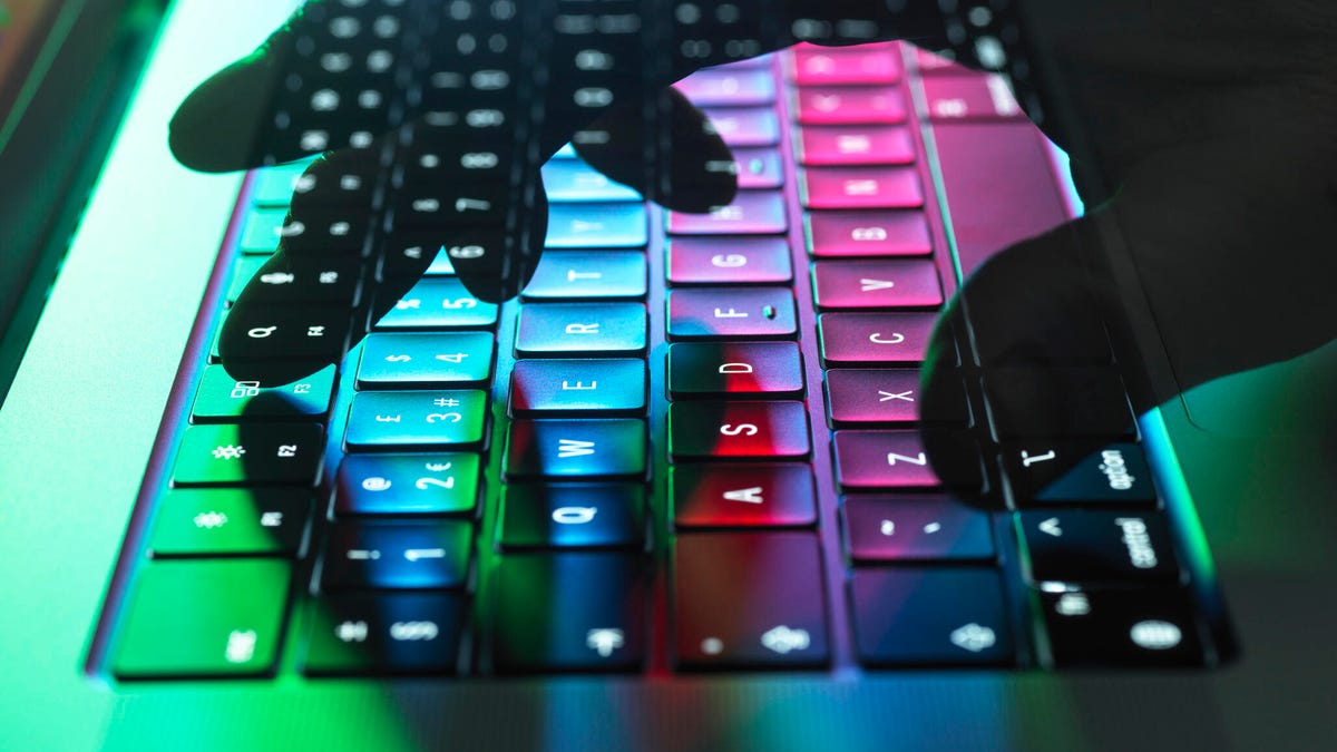 Atmospheric double exposure showing a transparent hand hovering over a computer keyboard.