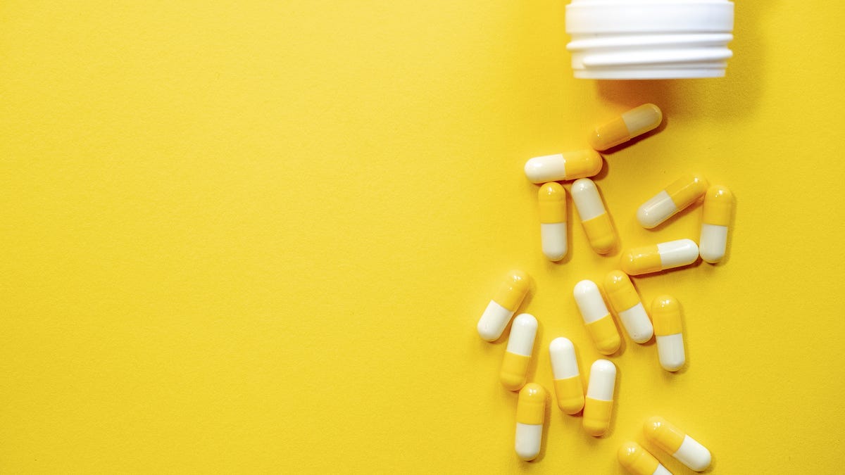 A bottle of medication against a yellow background