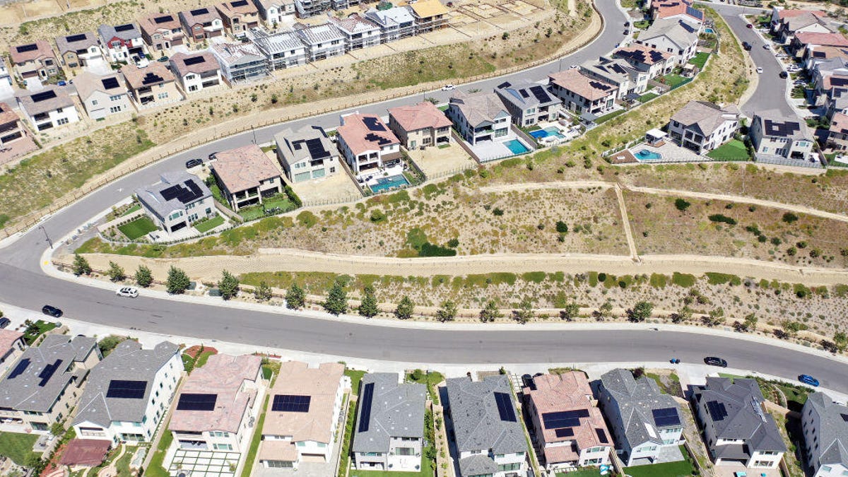 Aerial view of homes under construction with solar panels on top of them.