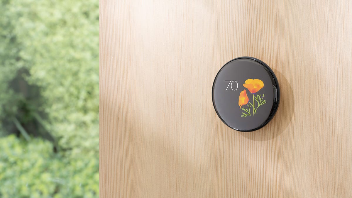 A Nest thermostat on a wall shows a poppy animation.