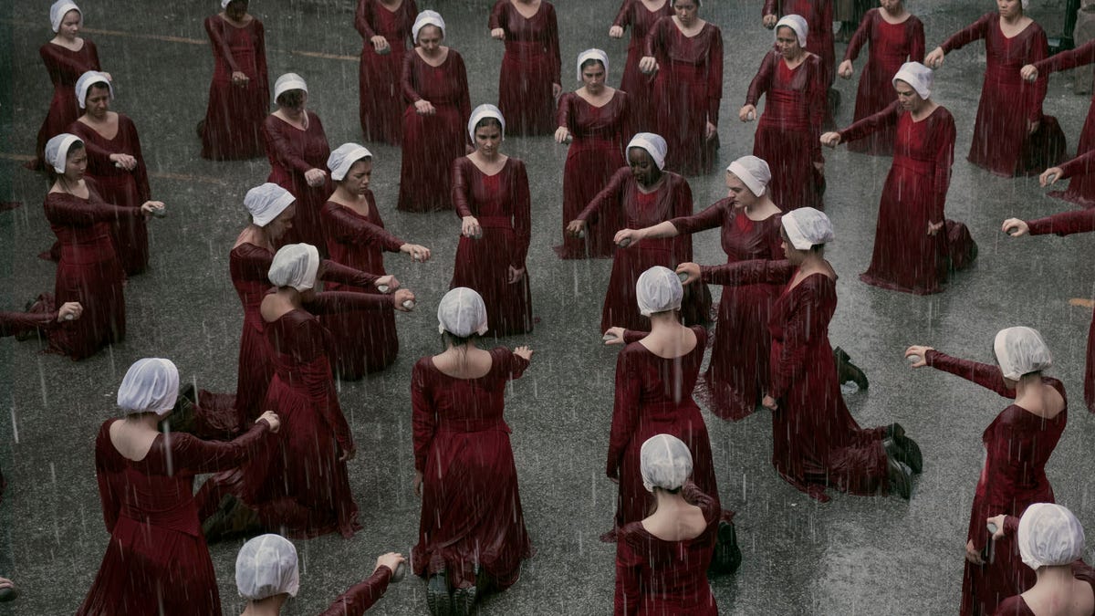 Handmaids gather in the rain in an episode of Hulu's The Handmaid's Tale