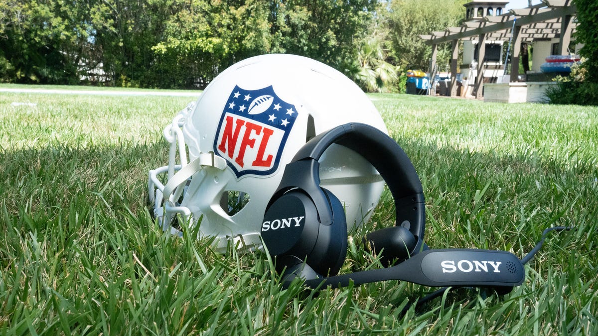The NFL coach's headset by Sony next to a football helmet on grass.