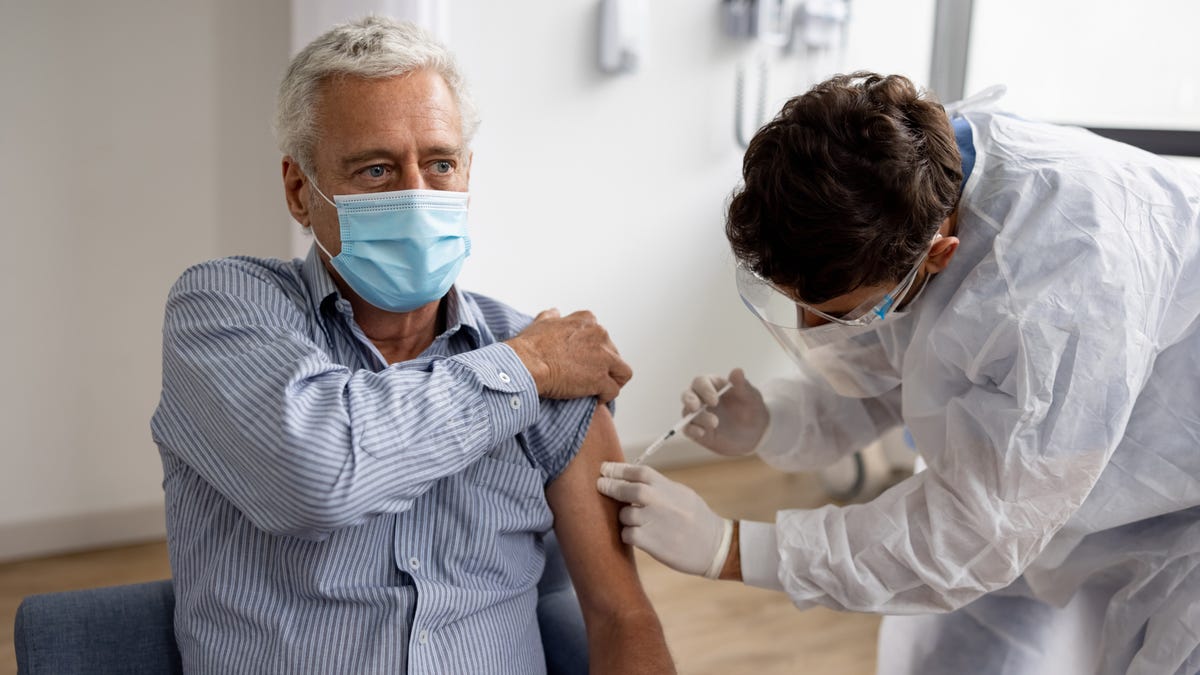 A man getting a COVID shot in a doctor's office.