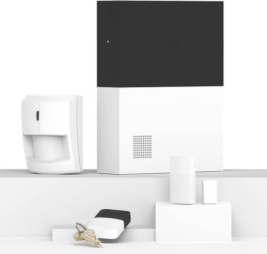 Abode devices like the hub, motion detector, and key fob stand on white shelves against a white background.