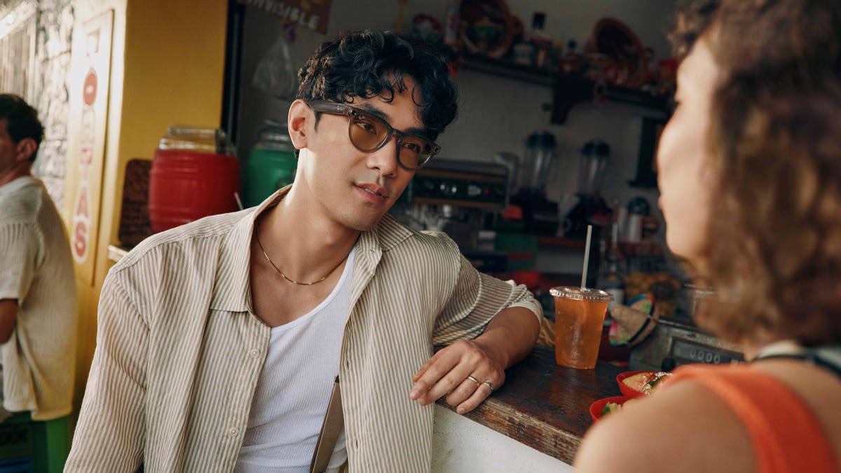 A man wearing Ray-Ban Meta glasses leans on a bar counter.