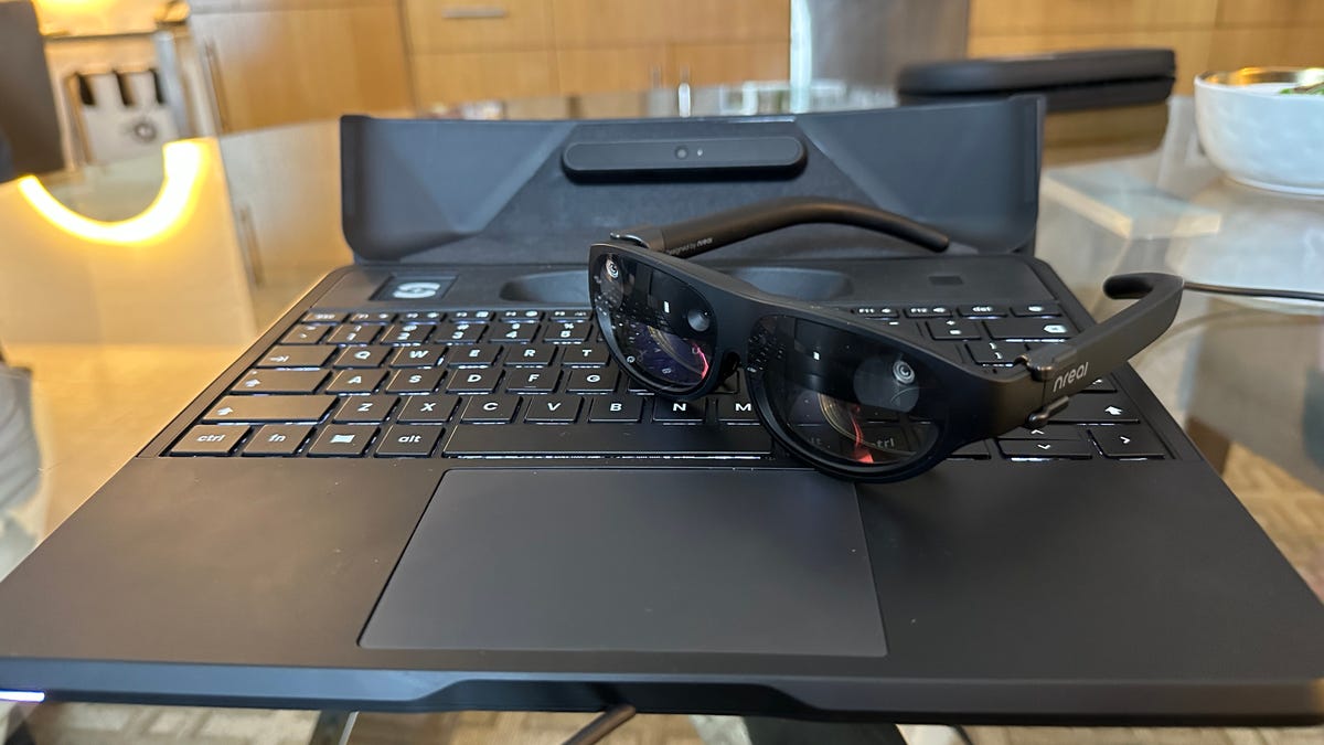 A laptop keyboard with a pair of AR glasses on top