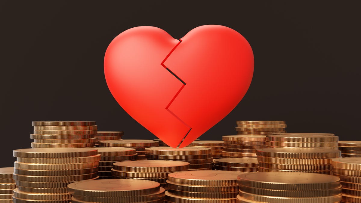 A photo-illustration showing a stylized broken heart atop a pile of coins.