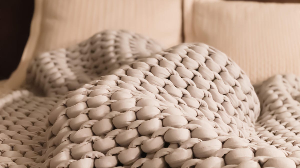 Beige-colored weighted blanket on a bed