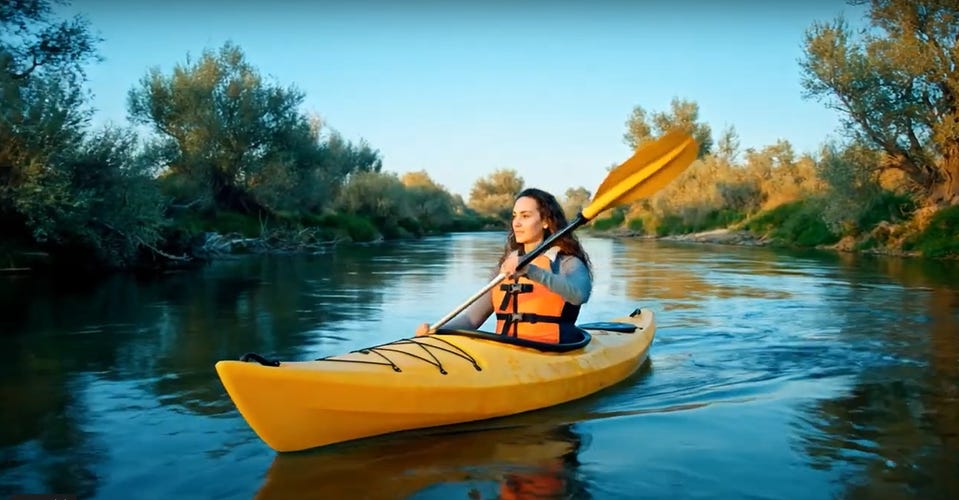 AI-generated image of a woman paddling a kayak on a river