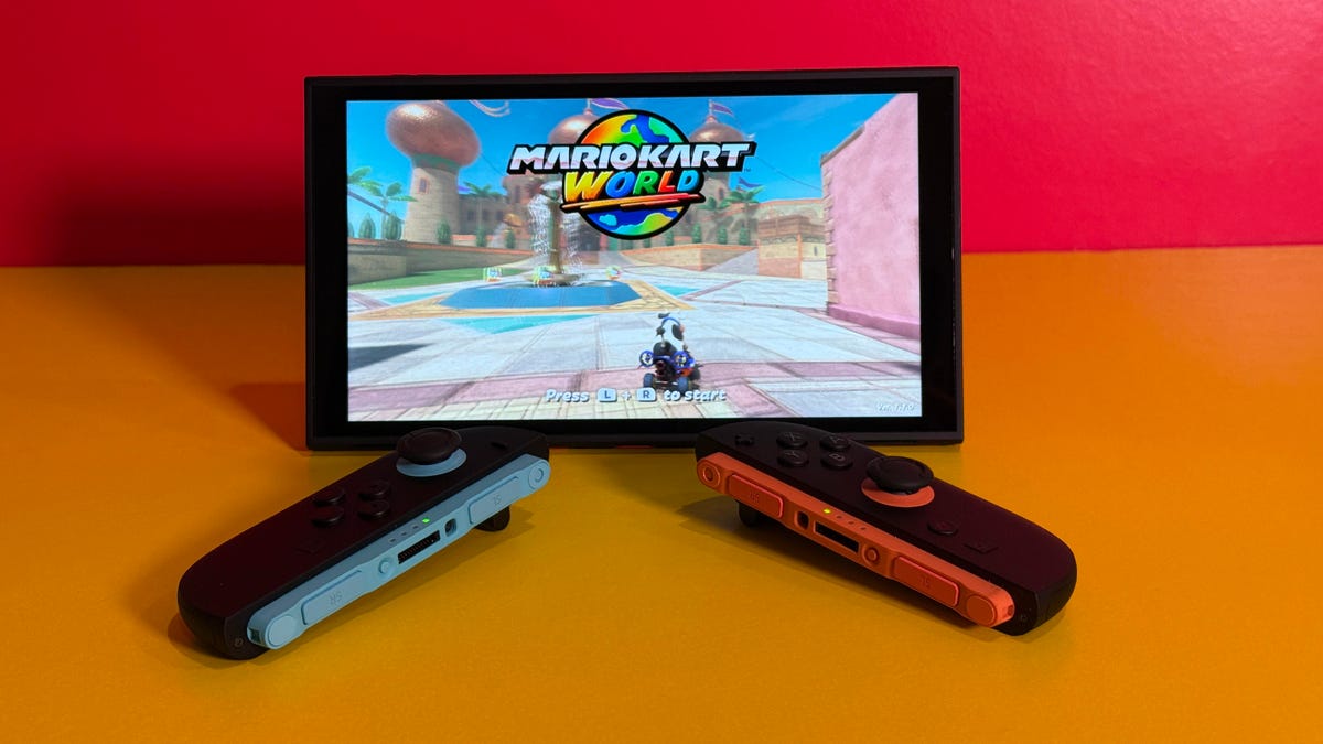 A Switch 2 on a table with controllers detached and Mario Kart World on the screen