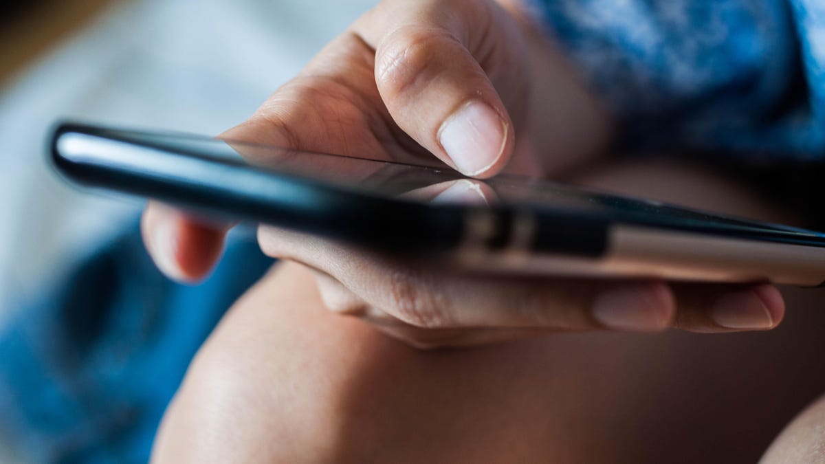 Hand holds a smartphone