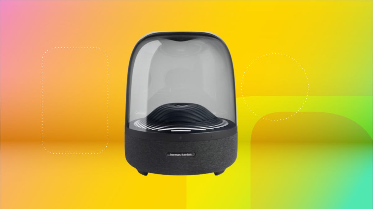 Black speaker with glass cylinder transparent case against golden yellow, yellow and mint green background.