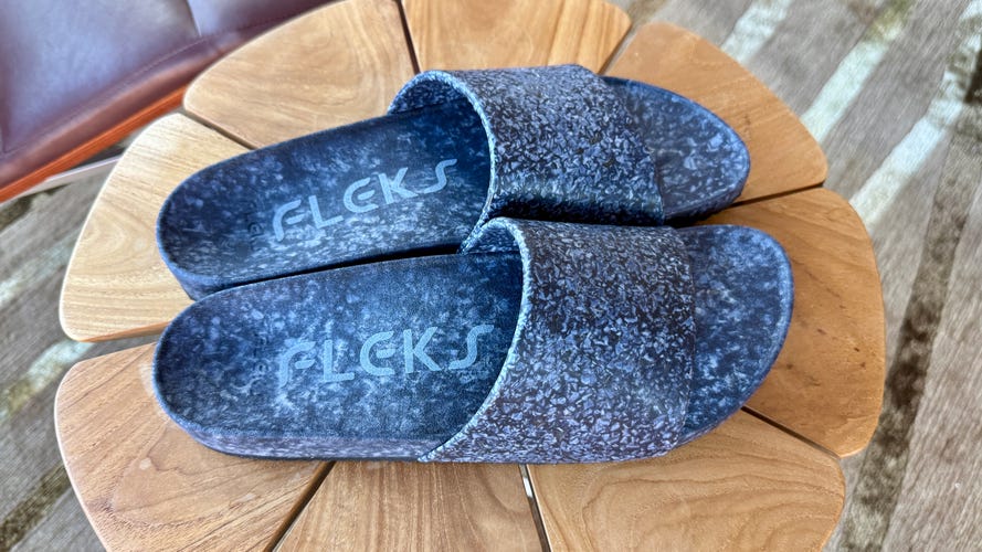 Fleck East Beach Slide sandals in blue on a side table