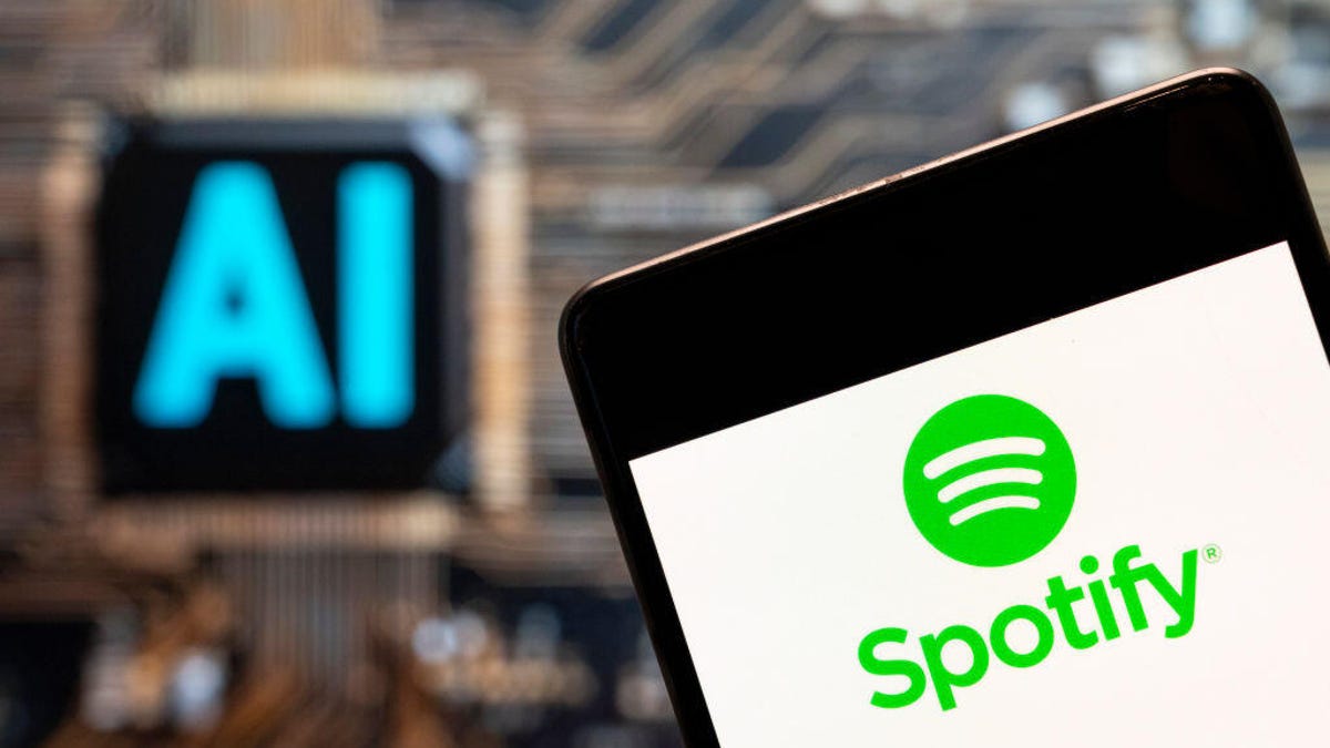 Spotify's logo on a phone in front of an AI computer logo.