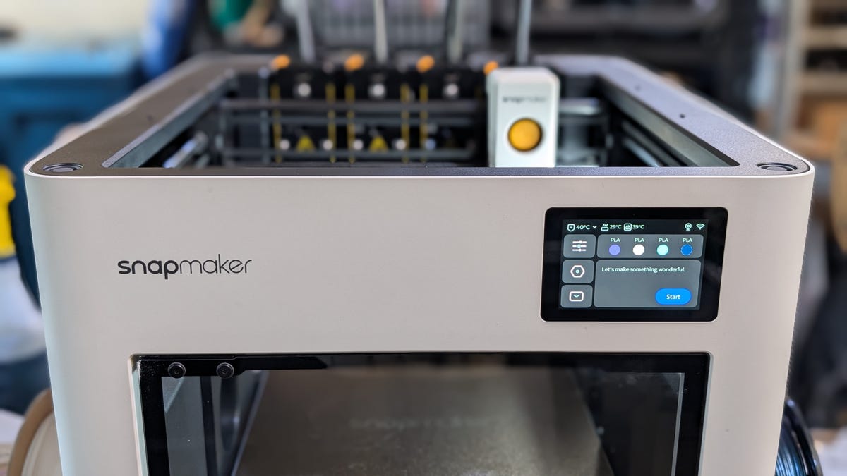 A white 3D printer with 4 tool heads instead of one